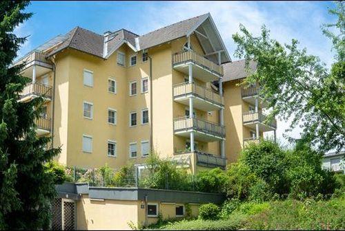 Gerbergasse 40 Willkommen in unserem modern und elegant gestalteten Wohnanlage, die von uns als Bauträger errichtet und verkauft wurden. Dieses Bild zeigt das schöne Äußere der modernen Gebäude, umgeben von Grün und Bäumen. Im Hintergrund können wir den klaren blauen Himmel und eine ferne Stadtlandschaft sehen. Diese Wohnanlage bietet luxuriöse Wohnräume, hochmoderne Annehmlichkeiten und eine friedliche Umgebung, die die Bewohner ihr Zuhause nennen können.