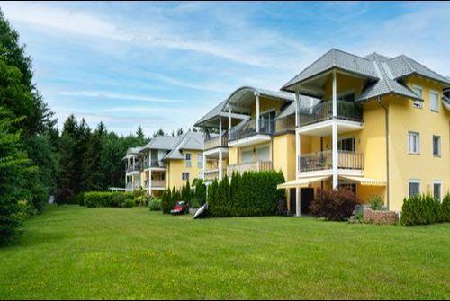 Goritschacherweg 51 / 53 Willkommen in unserem modern und elegant gestalteten Wohnanlage, die von uns als Bauträger errichtet und verkauft wurden. Dieses Bild zeigt das schöne Äußere der modernen Gebäude, umgeben von Grün und Bäumen. Im Hintergrund können wir den klaren blauen Himmel und eine ferne Stadtlandschaft sehen. Diese Wohnanlage bietet luxuriöse Wohnräume, hochmoderne Annehmlichkeiten und eine friedliche Umgebung, die die Bewohner ihr Zuhause nennen können.