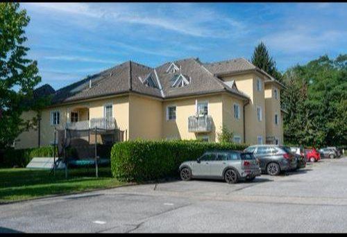 Kurzgasse 5 Willkommen in unserem modern und elegant gestalteten Wohnanlage, die von uns als Bauträger errichtet und verkauft wurden. Dieses Bild zeigt das schöne Äußere der modernen Gebäude, umgeben von Grün und Bäumen. Im Hintergrund können wir den klaren blauen Himmel und eine ferne Stadtlandschaft sehen. Diese Wohnanlage bietet luxuriöse Wohnräume, hochmoderne Annehmlichkeiten und eine friedliche Umgebung, die die Bewohner ihr Zuhause nennen können.