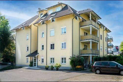 Gerbergasse 42 Willkommen in unserem modern und elegant gestalteten Wohnanlage, die von uns als Bauträger errichtet und verkauft wurden. Dieses Bild zeigt das schöne Äußere der modernen Gebäude, umgeben von Grün und Bäumen. Im Hintergrund können wir den klaren blauen Himmel und eine ferne Stadtlandschaft sehen. Diese Wohnanlage bietet luxuriöse Wohnräume, hochmoderne Annehmlichkeiten und eine friedliche Umgebung, die die Bewohner ihr Zuhause nennen können.