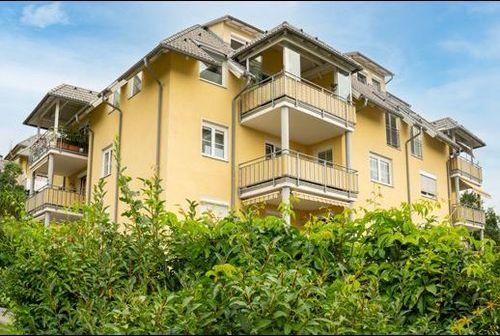 JÄgerweg 12 Willkommen in unserem modern und elegant gestalteten Wohnanlage, die von uns als Bauträger errichtet und verkauft wurden. Dieses Bild zeigt das schöne Äußere der modernen Gebäude, umgeben von Grün und Bäumen. Im Hintergrund können wir den klaren blauen Himmel und eine ferne Stadtlandschaft sehen. Diese Wohnanlage bietet luxuriöse Wohnräume, hochmoderne Annehmlichkeiten und eine friedliche Umgebung, die die Bewohner ihr Zuhause nennen können.