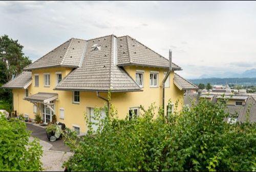 Ritterweg 5a Willkommen in unserem modern und elegant gestalteten Wohnanlage, die von uns als Bauträger errichtet und verkauft wurden. Dieses Bild zeigt das schöne Äußere der modernen Gebäude, umgeben von Grün und Bäumen. Im Hintergrund können wir den klaren blauen Himmel und eine ferne Stadtlandschaft sehen. Diese Wohnanlage bietet luxuriöse Wohnräume, hochmoderne Annehmlichkeiten und eine friedliche Umgebung, die die Bewohner ihr Zuhause nennen können.